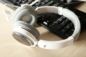 Headphones and keyboard on wooden table