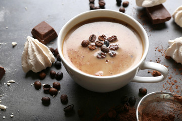 Cup of coffee and sweets on black wooden background