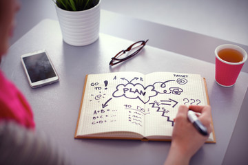 Young woman writes to diary on a white table