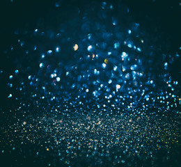 glitter vintage lights background. gold, silver, blue and black. de-focused.
