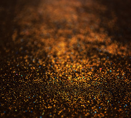 glitter vintage lights background. dark gold and black. defocused
