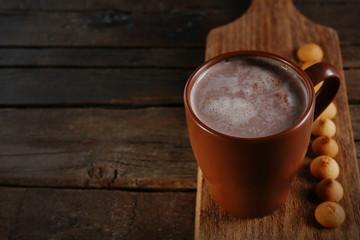 A cup of tasty cocoa on wooden table, close-up