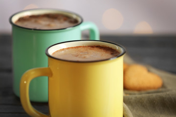 Tasty cocoa in metal old-fashioned mugs on the table