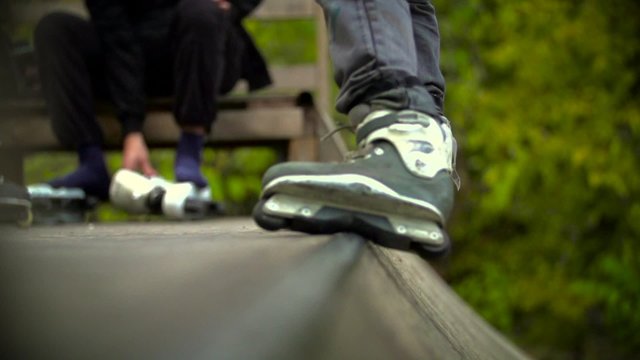 Teen with roller skates performing a stunt on a half pipe ramp Slow Motion 400 fps