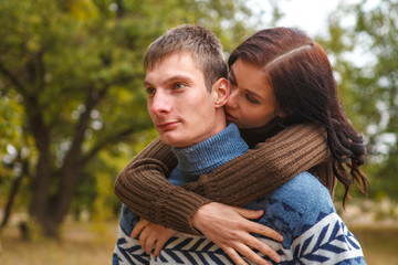 girl sitting on the back of a guy. A couple in love in the park