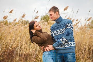 couple embraces on the shore of the pond in the park