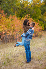 girl at the hands of Man. A loving couple walking in the autumn