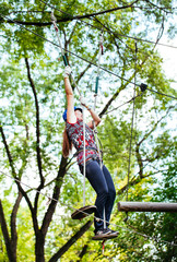 Adventure climbing high wire park - woman on course in mountain