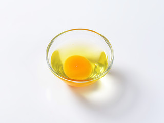 Egg white and yolk in glass bowl