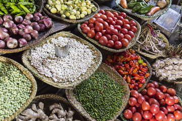 Different colorful raw grain and vegetables on shelfs on a market