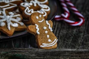 Gingerbread man standing next to plate full of cookies