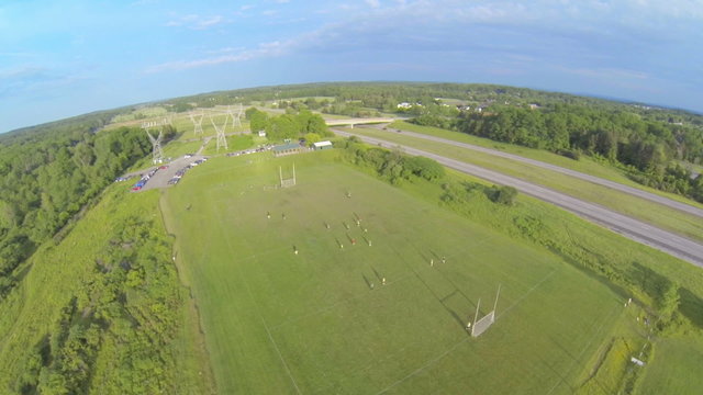 Aerial of People Playing on a Field. a high aerial wide angle shot of players on a playing field near a thruway
