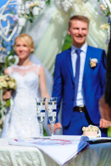 Glasses of champagne on the background blurred bride and groom