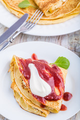 Pancakes with cottage cheese topped with strawberry jam and cream