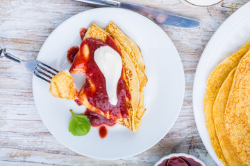 Pancakes with cottage cheese topped with strawberry jam and cream
