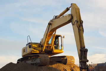 Obraz premium yellow excavator on sandpile in construction site