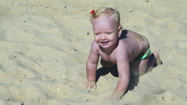 little child creeping through the sands of beach slow motion