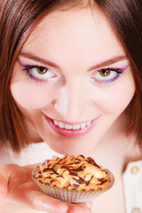 Smiling woman holds cake in hand