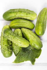 fresh organic cucumbers on a white wooden background.