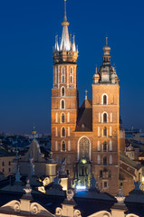 Fototapeta na wymiar Krakow, Poland, Virgin Mary church on the Main Market Square seen over Sukiennice (Cloth Hall) from the Town Hall tower in the night