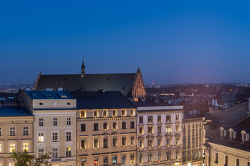 Holy Trinity church and building on the Main Market Square in the night seen from the Town Hall tower in Krakow, Poland