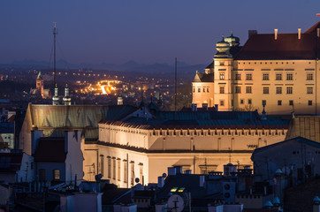 Fototapeta na wymiar Royal castle on the Wawel hill and new Town Hall in the night seen from the Town Hall tower in Krakow, Poland