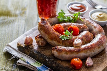 Grilled sausages served on wood board
