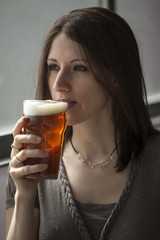 Beautiful Young Woman with Brown Hair Drinking a Pint