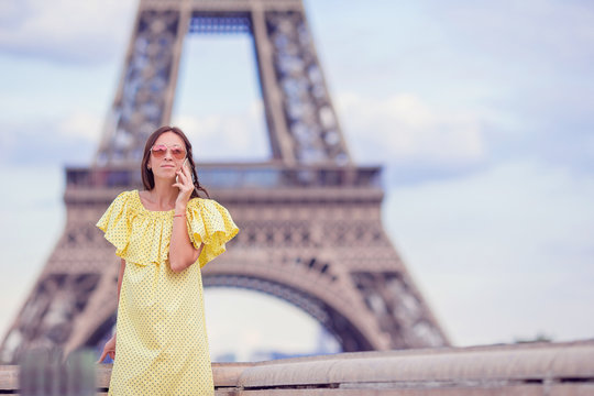 Young woman talking by phone background Eiffel Tower in Paris