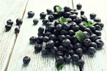 Fresh blueberries with mint on wooden table close up