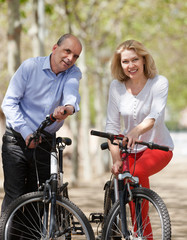 Man and woman walking with bicycles