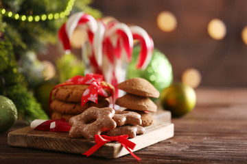 Christmas Candy Canes in glass with Christmas decoration on table on bright background