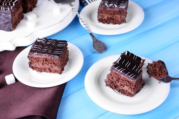 Served table with chocolate cake on blue background close-up