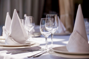 Table decorated with napkins, glasses and сutlery.