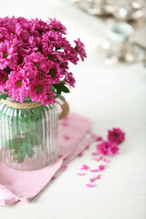 Beautiful flowers in vase on table in room