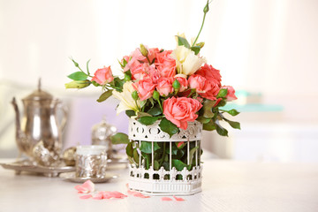 Beautiful rose in vase on table in room on bright background
