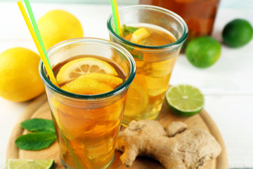 Iced tea with lemon on light wooden background