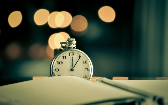 Pocket watch next to notebook. symbols of time
