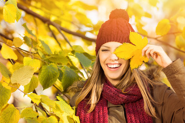 Beautiful young woman with autumn leaf