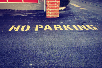 No parking sign on pavement in front of building, vintage style