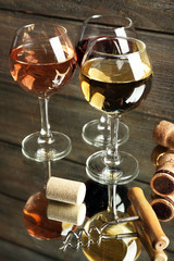 Wine glasses, corks and screw on wooden background