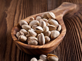 roasted and salted pistachios on wooden background