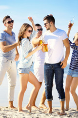 Obraz premium Young people with beer on the riverside