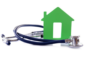 Concept of family medicine - green house and stethoscope isolated on white background
