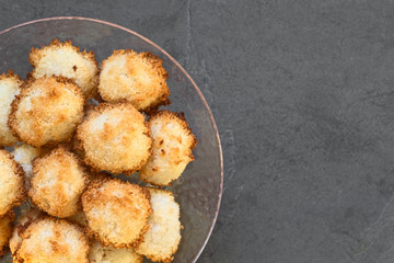 Homemade coconut macaroons (coconut meringue cookies), traditional German Christmas cookies called Kokosmakronen, photographed with natural light (Selective Focus, Focus on the top macaroons)