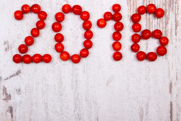 Happy new year 2016 made of red viburnum on old wooden background