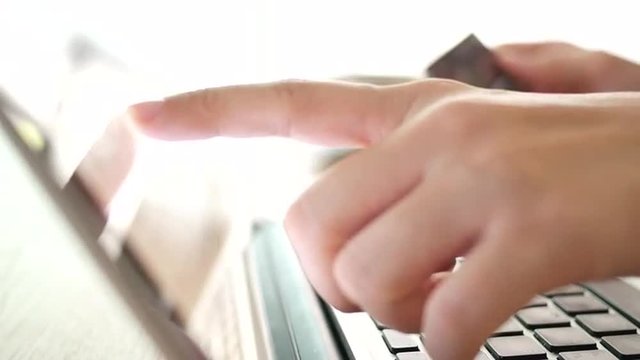 4K Woman's hands keying on keyboard and finger pointing on laptop monitor for  information checking. Use credit card for internet shopping online.