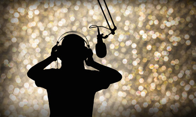 Entertainment background with silhouette of  singing or singer with headphone and microphone on beautiful bokeh  light in party and joyful event night or superstar search contest concept  - obrazy, fototapety, plakaty