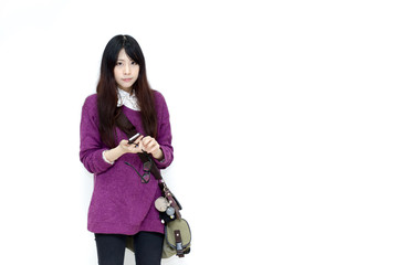 Asian girl in casual wear playing moblie phone