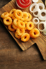 Chips rings with sauce and onion on cutting board